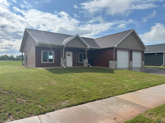 215 Aurora Ave, Spearfish, SD 57783 - view of front of property featuring board and batten siding, an attached garage, asphalt driveway, and a front lawn