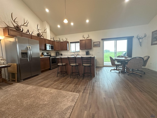 215 Aurora Ave, Spearfish, SD 57783 - kitchen with appliances with stainless steel finishes, light countertops, dark wood-style floors, a breakfast bar, and recessed lighting