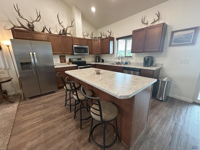 215 Aurora Ave, Spearfish, SD 57783 - kitchen with stainless steel appliances, light countertops, dark wood finished floors, a breakfast bar area, and high vaulted ceiling