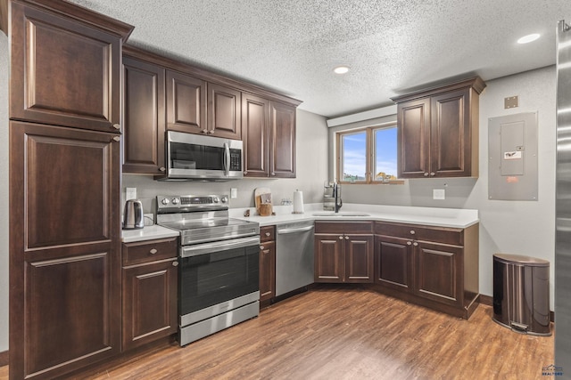 5642 Bob Ln, Black Hawk, SD 57718 - kitchen with appliances with stainless steel finishes, a textured ceiling, wood finished floors, light countertops, and dark brown cabinetry