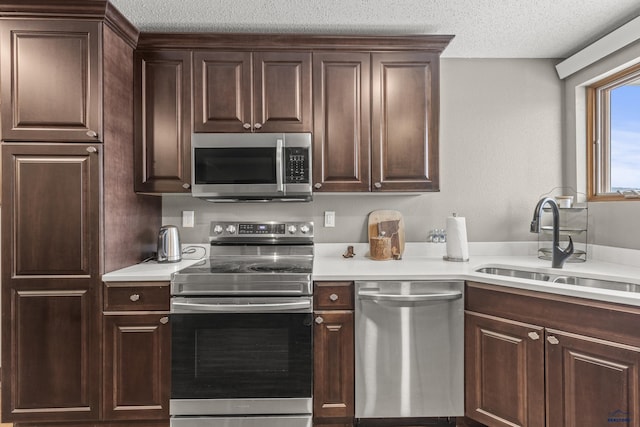5642 Bob Ln, Black Hawk, SD 57718 - kitchen with appliances with stainless steel finishes, light countertops, dark brown cabinetry, and a textured ceiling