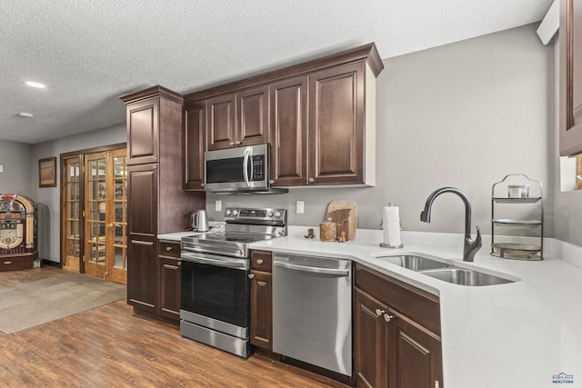 5642 Bob Ln, Black Hawk, SD 57718 - kitchen with appliances with stainless steel finishes, dark wood-style flooring, light countertops, dark brown cabinets, and a textured ceiling
