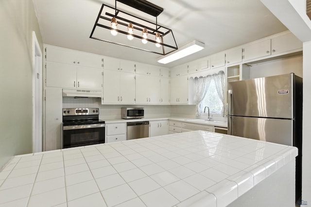 4340 Timothy, Rapid City, SD 57702 - kitchen featuring stainless steel appliances, white cabinets, under cabinet range hood, and tile countertops