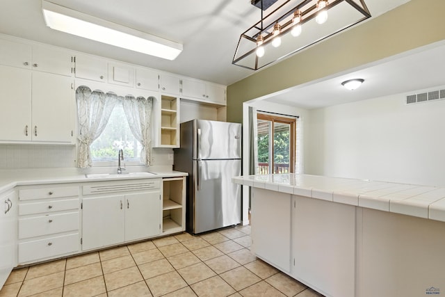 4340 Timothy, Rapid City, SD 57702 - kitchen featuring freestanding refrigerator, open shelves, light tile patterned flooring, and white cabinetry