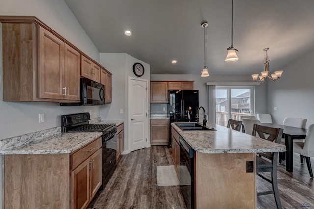 613 Civil Way, Box Elder, SD 57719 - kitchen with black appliances, dark wood-style floors, a kitchen bar, a center island with sink, and light countertops