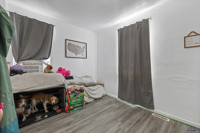 911 Haines Ave, Rapid City, SD 57701 - bedroom featuring wood finished floors, cooling unit, and a textured wall