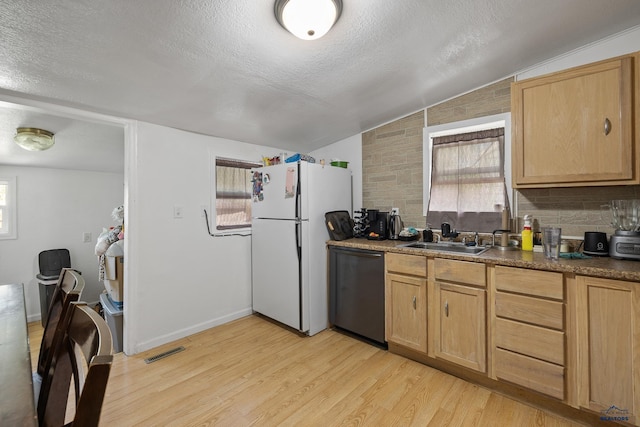 911 Haines Ave, Rapid City, SD 57701 - kitchen featuring dishwasher, vaulted ceiling, freestanding refrigerator, a textured ceiling, and light wood finished floors