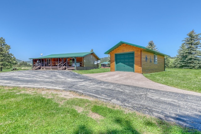 20813 Legends Ln, Sturgis, SD 57785 - view of front of home with an outdoor structure, a detached garage, asphalt driveway, log exterior, and a front yard