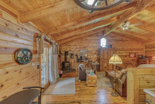 20813 Legends Ln, Sturgis, SD 57785 - unfurnished room featuring a wood stove, wooden walls, wood ceiling, hardwood / wood-style floors, and a ceiling fan