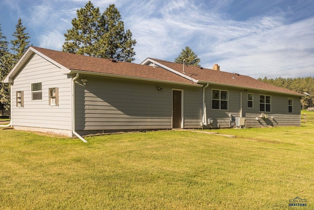 13000 Deer Creek Ln, Rapid City, SD 57702 - back of house featuring a yard, roof with shingles, and a chimney