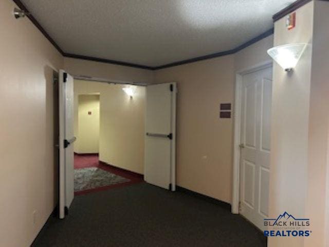 3600 Sheridan Lake Rd Unit # 222, Rapid City, SD 57702 - corridor with a textured ceiling, crown molding, and dark carpet