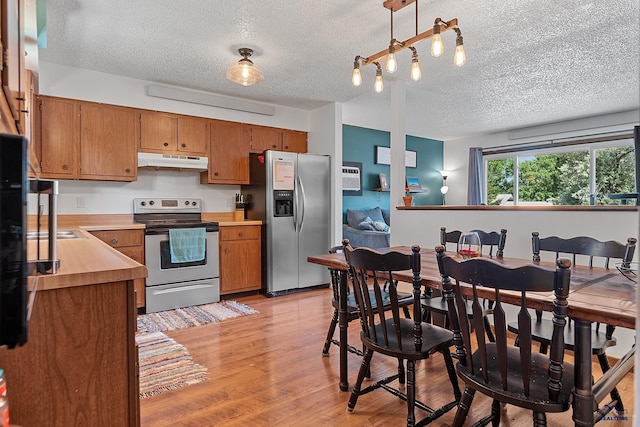 2613 Moose Dr, Sturgis, SD 57785 - kitchen featuring appliances with stainless steel finishes, under cabinet range hood, a textured ceiling, light countertops, and brown cabinets
