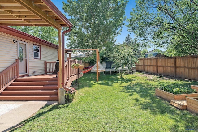 2613 Moose Dr, Sturgis, SD 57785 - fenced backyard with a trampoline, a vegetable garden, and a deck