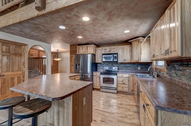 23217 Carbon Loop, Rapid City, SD 57702 - kitchen with appliances with stainless steel finishes, a kitchen breakfast bar, brick floors, backsplash, and a center island