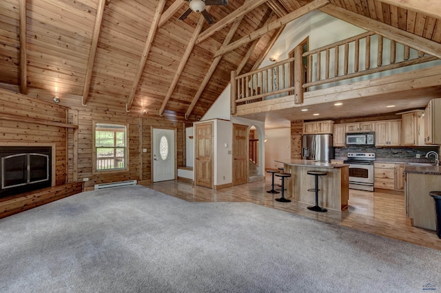 23217 Carbon Loop, Rapid City, SD 57702 - unfurnished living room featuring high vaulted ceiling, a wood ceiling with exposed beams, a baseboard radiator, light carpet, and arched walkways