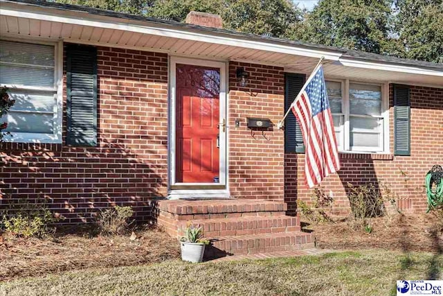 doorway to property with brick siding