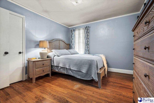 bedroom with baseboards, crown molding, and wood finished floors