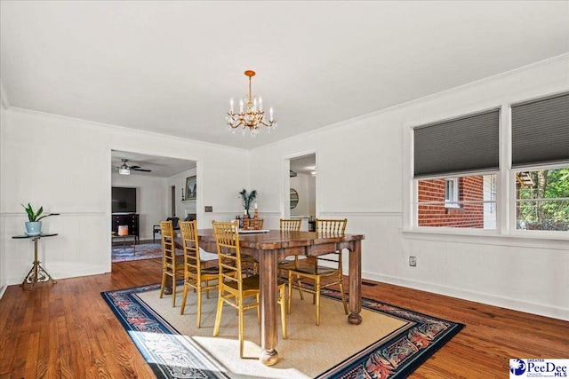 dining area featuring ornamental molding, wainscoting, and wood finished floors