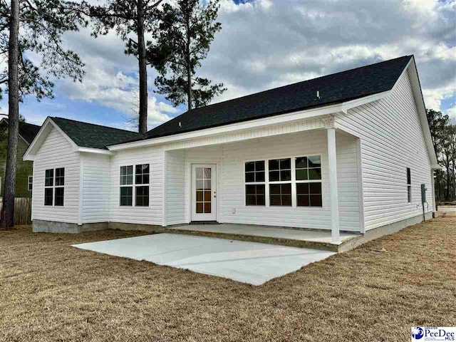 rear view of property with a patio and a lawn