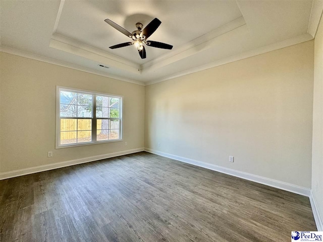 unfurnished room with crown molding, dark wood-type flooring, ceiling fan, and a tray ceiling