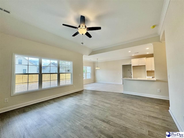 unfurnished living room featuring dark wood-type flooring, ceiling fan, and sink