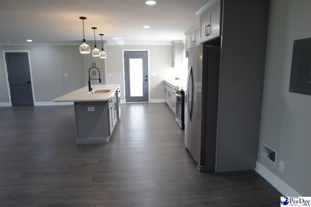 kitchen featuring sink, white cabinetry, hanging light fixtures, stainless steel appliances, and an island with sink