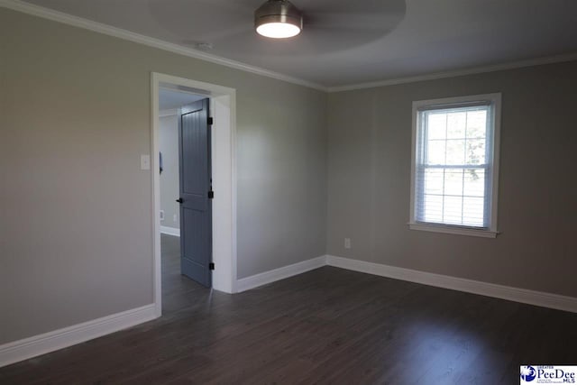 empty room featuring dark wood-type flooring and crown molding