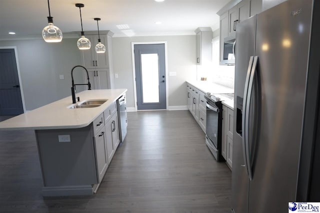 kitchen featuring decorative light fixtures, an island with sink, sink, ornamental molding, and stainless steel appliances