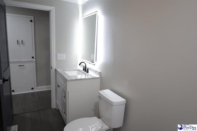 bathroom featuring vanity, hardwood / wood-style flooring, and toilet