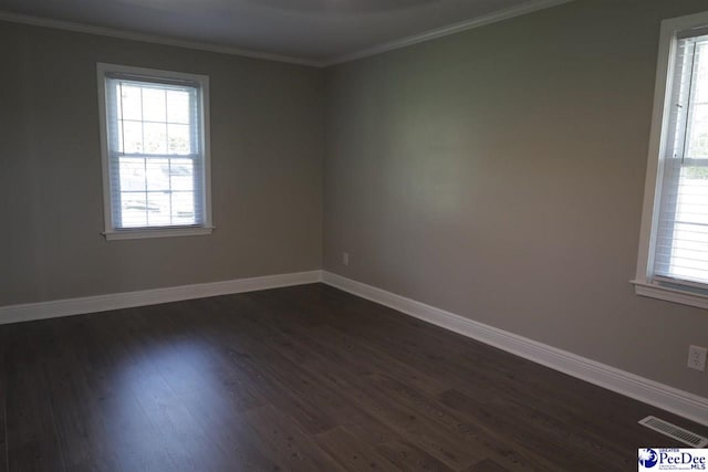 unfurnished room featuring ornamental molding, dark wood-type flooring, and a wealth of natural light