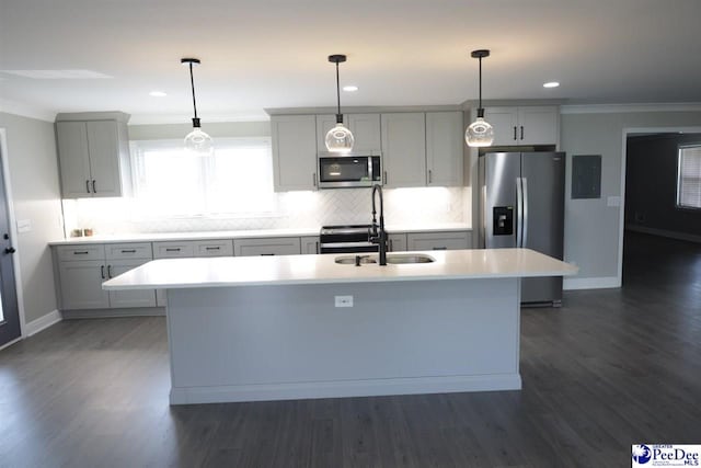 kitchen with stainless steel appliances, an island with sink, hanging light fixtures, and sink