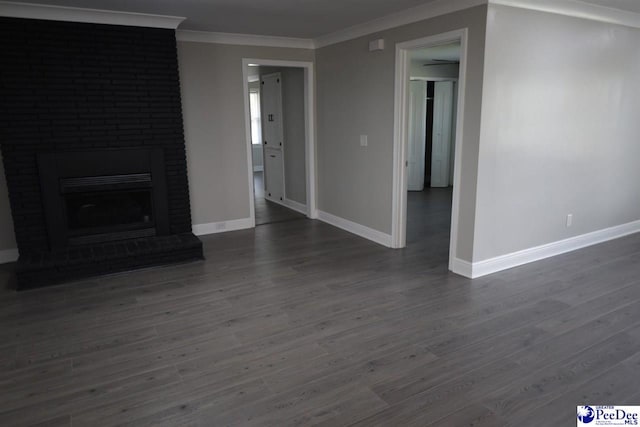 unfurnished living room with crown molding, a brick fireplace, and dark hardwood / wood-style floors