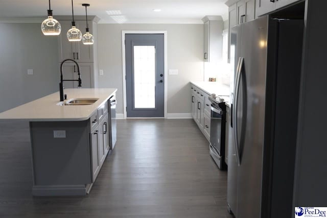 kitchen featuring sink, crown molding, stainless steel appliances, a center island with sink, and decorative light fixtures