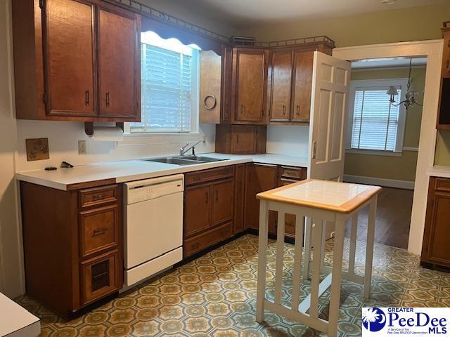 kitchen featuring sink, a notable chandelier, a wealth of natural light, and dishwasher