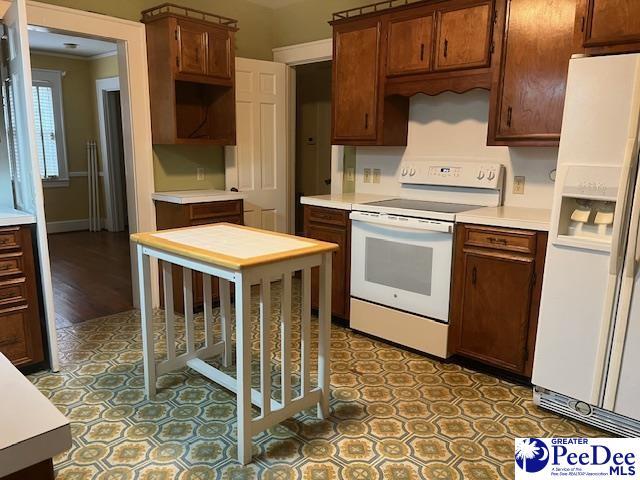 kitchen featuring crown molding and white appliances