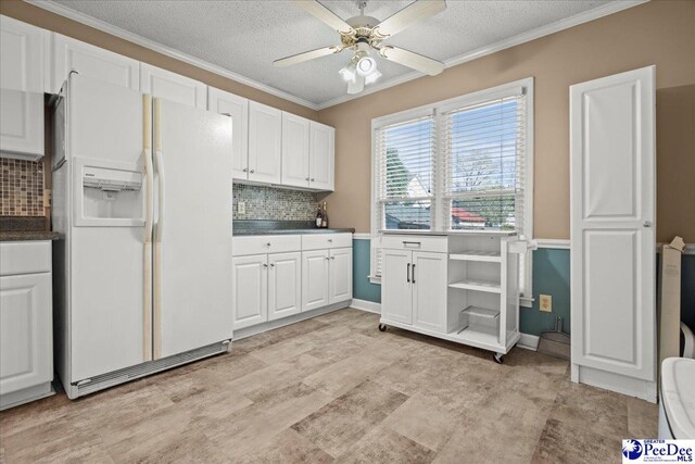 316 Magna Carta Rd, Florence, SC 29501 - kitchen with backsplash, white fridge with ice dispenser, dark countertops, and white cabinetry