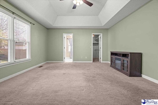 316 Magna Carta Rd, Florence, SC 29501 - unfurnished living room with a ceiling fan, a tray ceiling, a textured ceiling, carpet flooring, and baseboards