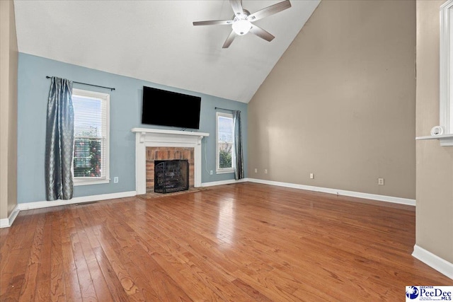 316 Magna Carta Rd, Florence, SC 29501 - unfurnished living room with a ceiling fan, baseboards, high vaulted ceiling, hardwood / wood-style flooring, and a brick fireplace