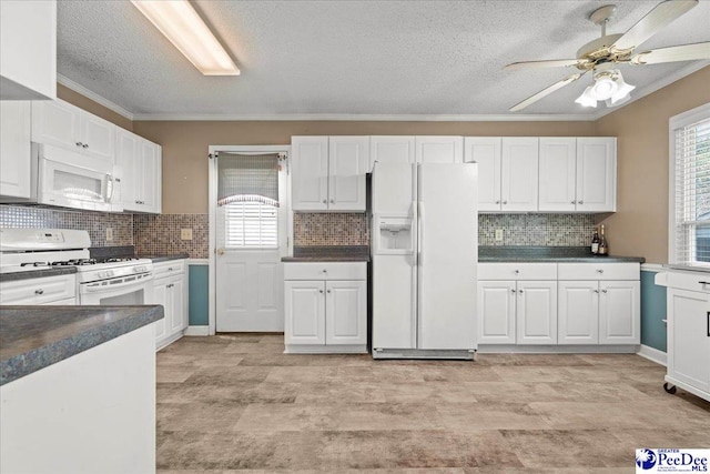 316 Magna Carta Rd, Florence, SC 29501 - kitchen with white appliances, dark countertops, ornamental molding, and white cabinetry
