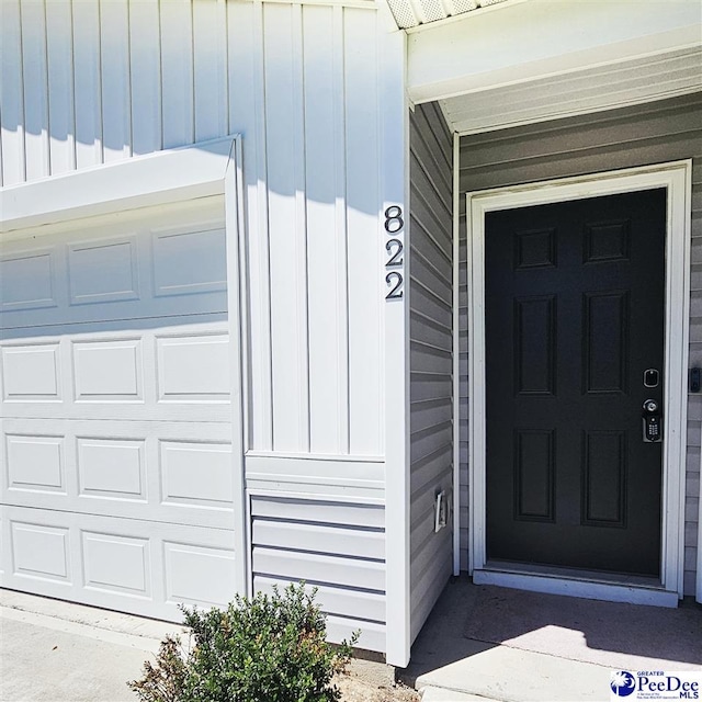 822 Twin Oaks Cir, Lake City, SC 29560 - property entrance with board and batten siding and a garage