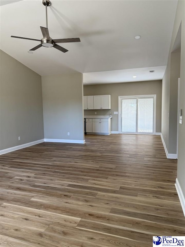 unfurnished living room with hardwood / wood-style flooring, ceiling fan, and vaulted ceiling