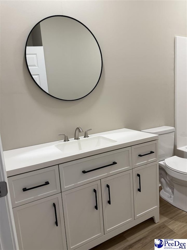 bathroom with vanity, hardwood / wood-style flooring, and toilet