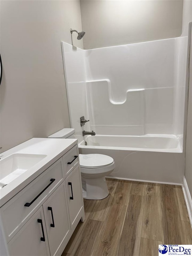 full bathroom with vanity, hardwood / wood-style floors, bathing tub / shower combination, and toilet