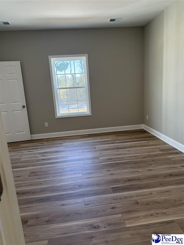 unfurnished room with dark wood-type flooring