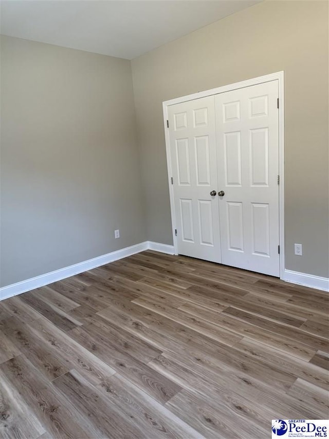 unfurnished bedroom featuring hardwood / wood-style flooring and a closet