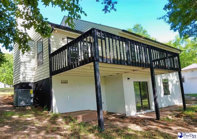 rear view of property with cooling unit and a deck