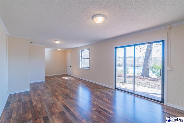 spare room with ornamental molding, a water view, concrete block wall, and wood finished floors