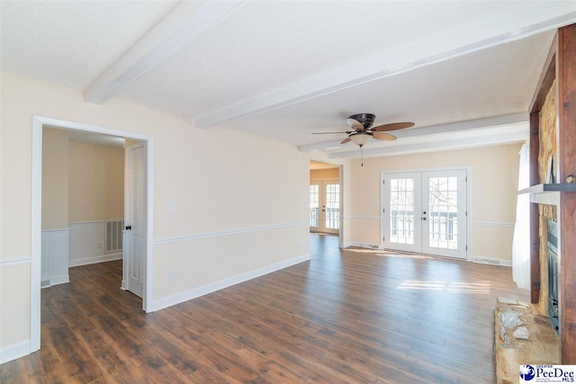 unfurnished living room with visible vents, a fireplace with raised hearth, beam ceiling, french doors, and dark wood-style floors