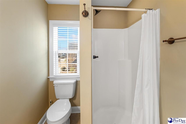 bathroom featuring curtained shower and toilet