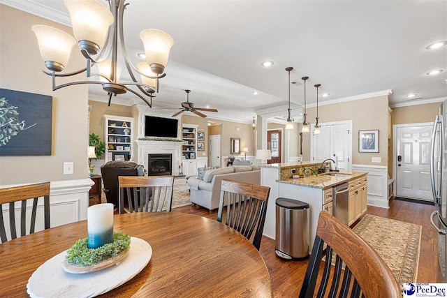 dining room featuring crown molding, dark hardwood / wood-style floors, ceiling fan with notable chandelier, and sink